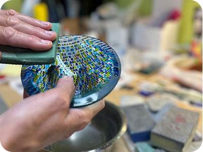 Gabrielle Baumann using a handipad on her glass art